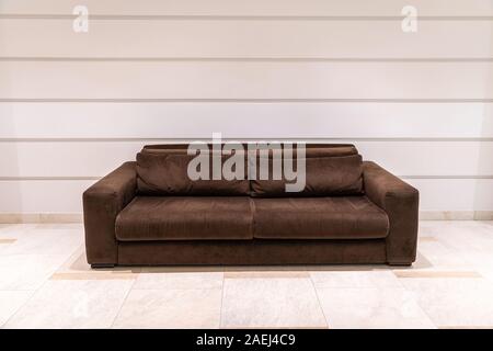 Modern brown textile couch with light wall and copy space Stock Photo