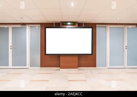 Blank big monitor in public place. Billboard mockup near doors Stock Photo