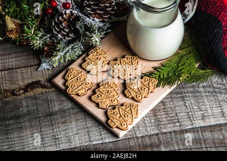 Fresh milk and Christmas cookies with Christmas decorations on a wooden table Stock Photo