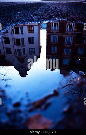 Buildings are reflected in a winter puddle Stock Photo - Alamy