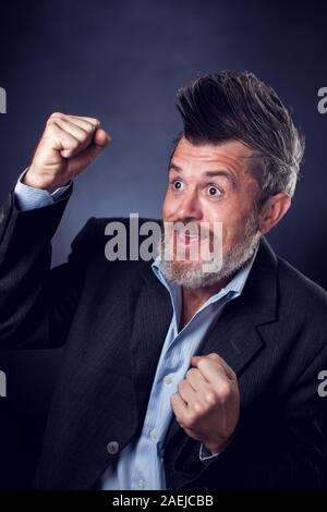 A portrait of funny lucky bearded man with iroquois wearing suit. People and emotions concept Stock Photo