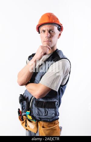 The builder thought. In work clothes and hard hat. Stock Photo