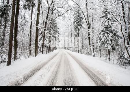 Snow covered road through a forest Stock Photo - Alamy