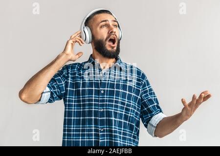Mature bearded man singing, listening music in headphones Stock Photo