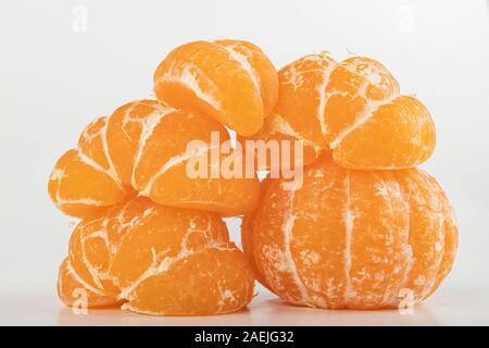 Tasty ripe mandarin on a white table. Peeled citruses. Light background. Stock Photo