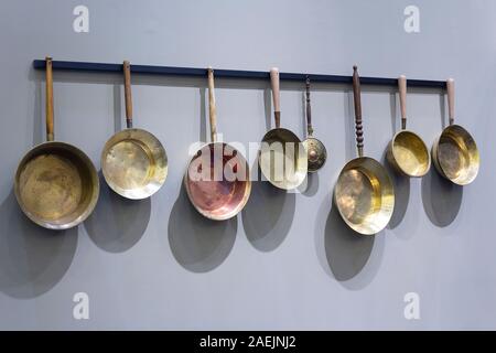 Vintage copper frying pans on the wall Stock Photo