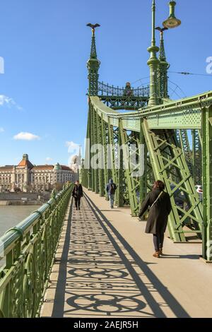 BUDAPEST, HUNGARY - MARCH 2019: Person walking across the Liberty Bridge or Freedom Bridge as it is known, which crosses the River Danube in Budapest Stock Photo