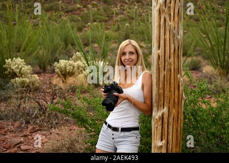 Female nature lover photographing the saguaro cactus (Carnegiea gigantea) with her professional camera in Saguaro National Park, Arizona, USA Stock Photo