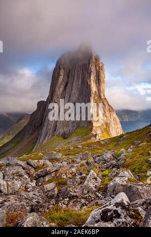 View from Mount Hesten on Iconic Mountain Segla in light of epic sunsetcovered in fog and mountain range in background, Fjordgard, Senja, Norway sunse