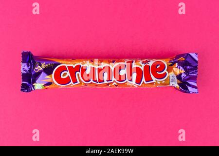 A Crunchie chocolate bar shot on a pink background. Stock Photo