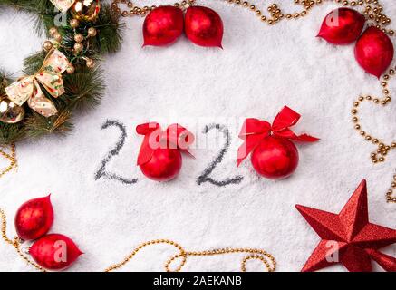 2020 on Christmas snowy background with red decorations Stock Photo