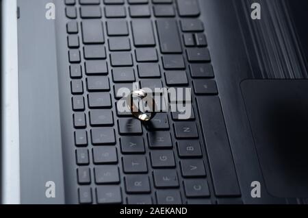 STARGATE: A gold ring appears on the keyboard of a laptop computer. Stock Photo