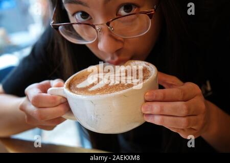 Middletown, CT USA. Oct 2018. Cinnamon or espresso powder coating close up on this latte being consumed by a conscious customer. Stock Photo