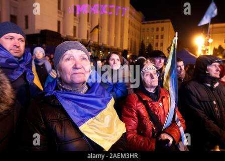 Kiev, Ukraine. 09th Dec, 2019. Ukrainians watch a joint news conference following the Normandy Four leaders summit, Volodymyr Zelensky, Vladimir Putin, Angela Merkel and Emmanuel Macron, outside the Presidential Office in Kiev.A Normandy Format summit with the participation of leaders of Ukraine, Russia, France and Germany regarding the conflicts in eastern Ukraine was held in Paris. Credit: SOPA Images Limited/Alamy Live News