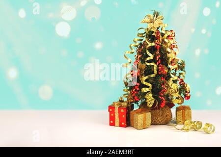 Decorated Christmas tree with gift boxes and snow lights bokeh, free copy space. Stock Photo
