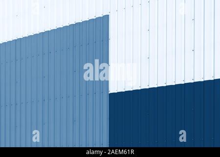 Brightly colored industrial warehouse exterior wall as background. Color of the year 2020 classic blue toned Stock Photo