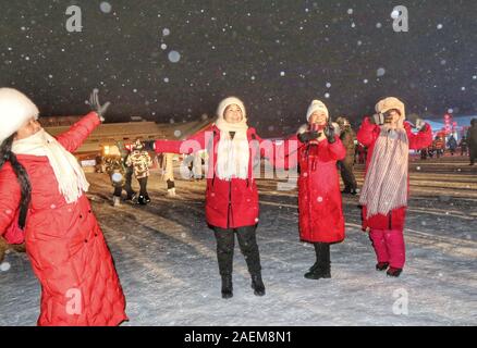 Peope dance at the Snow Carnival at the China Snow Town in Mudanjiang city, north-east China's Heilongjiang province, 27 November 2019.   To attract m Stock Photo