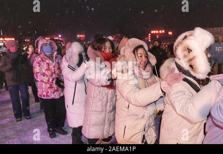 Peope dance at the Snow Carnival at the China Snow Town in Mudanjiang city, north-east China's Heilongjiang province, 27 November 2019.   To attract m Stock Photo