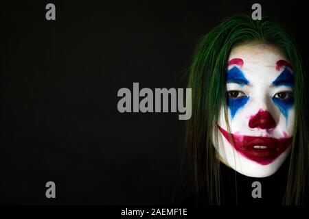 Clown make-up for Halloween. Close-up face on black background. Stock Photo