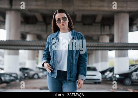 One person only. Portrait of beautiful young woman standing under the bridge outdoors Stock Photo