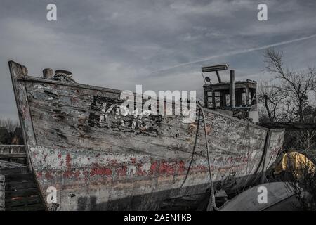 Abandoned fishing boat pulled ashore Stock Photo