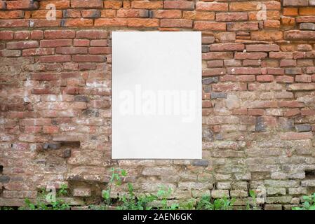 Poster glued to old brick wall. Blank, clean white paper for mockup, design presentation Stock Photo