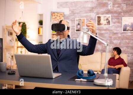 Elderly man experiencing new virtual reality technology for the first time in his home Stock Photo