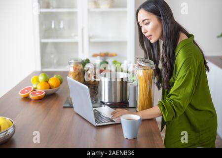 Cook focusing her attention on a computer Stock Photo