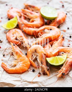 Shrimps served with lemons and spices on a paper background Stock Photo