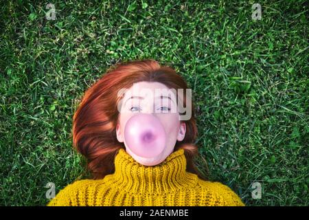 Young Woman Chewing Gum And Making Big Balloon Stock Photo