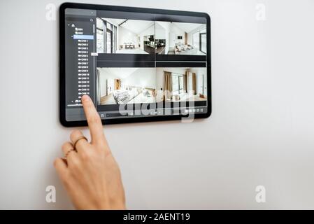 Controlling home with video cameras and digital tablet. Concept of remote video surveillance over the internet with smart touch screen devices Stock Photo