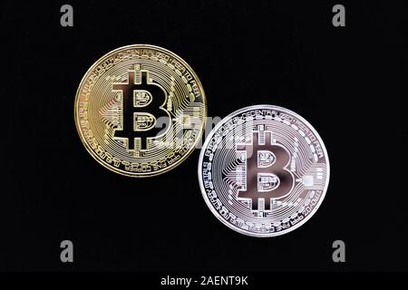 Silver and gold bitcoins on black background. Bitcoin mining concept. A two shiny coins of cryptocurrency on dark backdrop. Virtual money Stock Photo