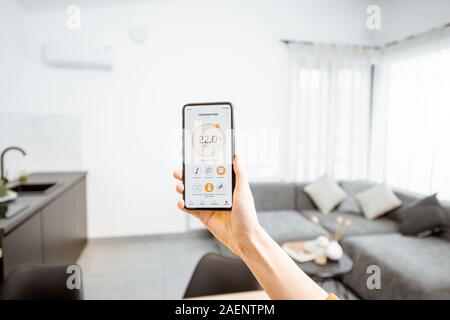 Controlling home heating temperature with a smart home, close-up on phone. Concept of a smart home and mobile application for managing smart devices at home Stock Photo