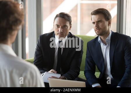 Two serious doubting hr managers listening to candidate in job interview Stock Photo