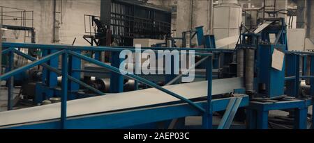 Sheet metal cutting and forming machine for the production of steel pipes, tubes and metal profiles in the factory. Concept for metalwork production. Stock Photo