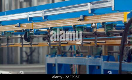 The industrial device for corrugated metal sheets bending by high precision machine in factory. Blue line machine conveyor for cutting sheet metal in Stock Photo