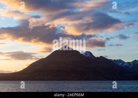 Dramatic sunset with clouds over Black Cuillin hills on Isle of Skye, Scotland, UK in March - long exposure Stock Photo