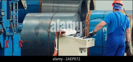 Engineer checking and controlling automatic machine in mechanical workshop, monitoring system software. Digital manufacturing operation. Concept for m Stock Photo