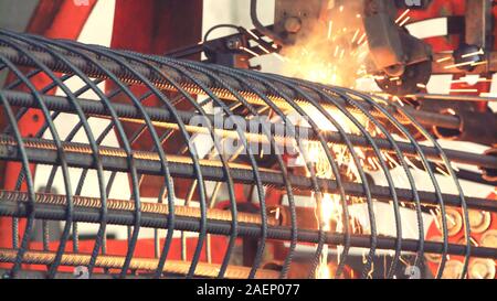 Automatic Welding fittings with electrodes. Electrode weld reinforcing bars. Sparks crumble to the side. Welding iron rods. Stock Photo