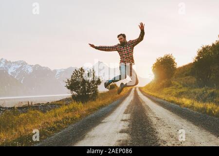 Man jumping over mountain road outdoor travel lifestyle adventure vacations activity in Norway freedom success concept happy positive vibes emotions Stock Photo