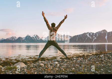 Happy man traveler jumping outdoor travel lifestyle adventure vacations activity in Norway success concept happiness positive vibes emotions Stock Photo