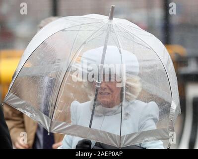 The Duchess of Cornwall uses an umbrella to shelter from the rain as she arrives for the commissioning ceremony of the Royal Navy aircraft carrier, HMS Prince of Wales, at Portsmouth Naval Base. Stock Photo