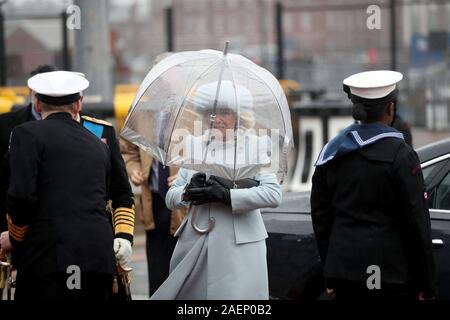 The Duchess of Cornwall uses an umbrella to shelter from the rain as she arrives for the commissioning ceremony of the Royal Navy aircraft carrier, HMS Prince of Wales, at Portsmouth Naval Base. Stock Photo