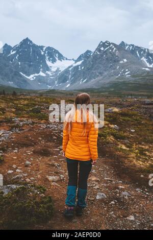 Traveler woman enjoying mountains view outdoor adventure hiking activity vacations alone healthy lifestyle woman exploring Lyngen Alps in Norway Stock Photo