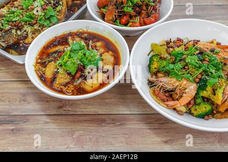 Assorted traditional dishes such as Fragrant Hotpot, Spicy boiled fish, mini lobsters, Chongqing grilled fish. Flat lay top down view of table of auth Stock Photo