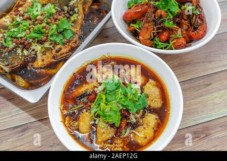 Assorted traditional dishes such, Spicy boiled fish, mini lobsters, Chongqing grilled fish. Flat lay top down view of table of authentic Asia, China S Stock Photo