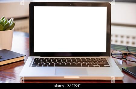 Computer screen mockup. Laptop with white blank screen on a wood desk, office background, copy space Stock Photo
