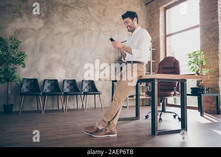 Full body profile side photo of confident smart middle eastern joyful businessman using smartphone send message to work colleagues partners feel Stock Photo