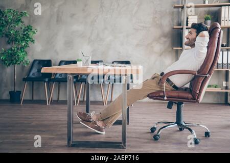 Profile side full body photo of positive multiethnic middle eastern entrepreneur finish project have break on work sit brown leather armchair table Stock Photo