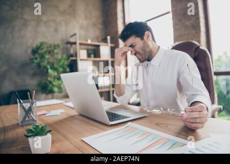 Profile side photo of exhausted middle eastern entrepreneur have lots work on computer touch his nose hold glasses feel burnout sit desk in loft Stock Photo